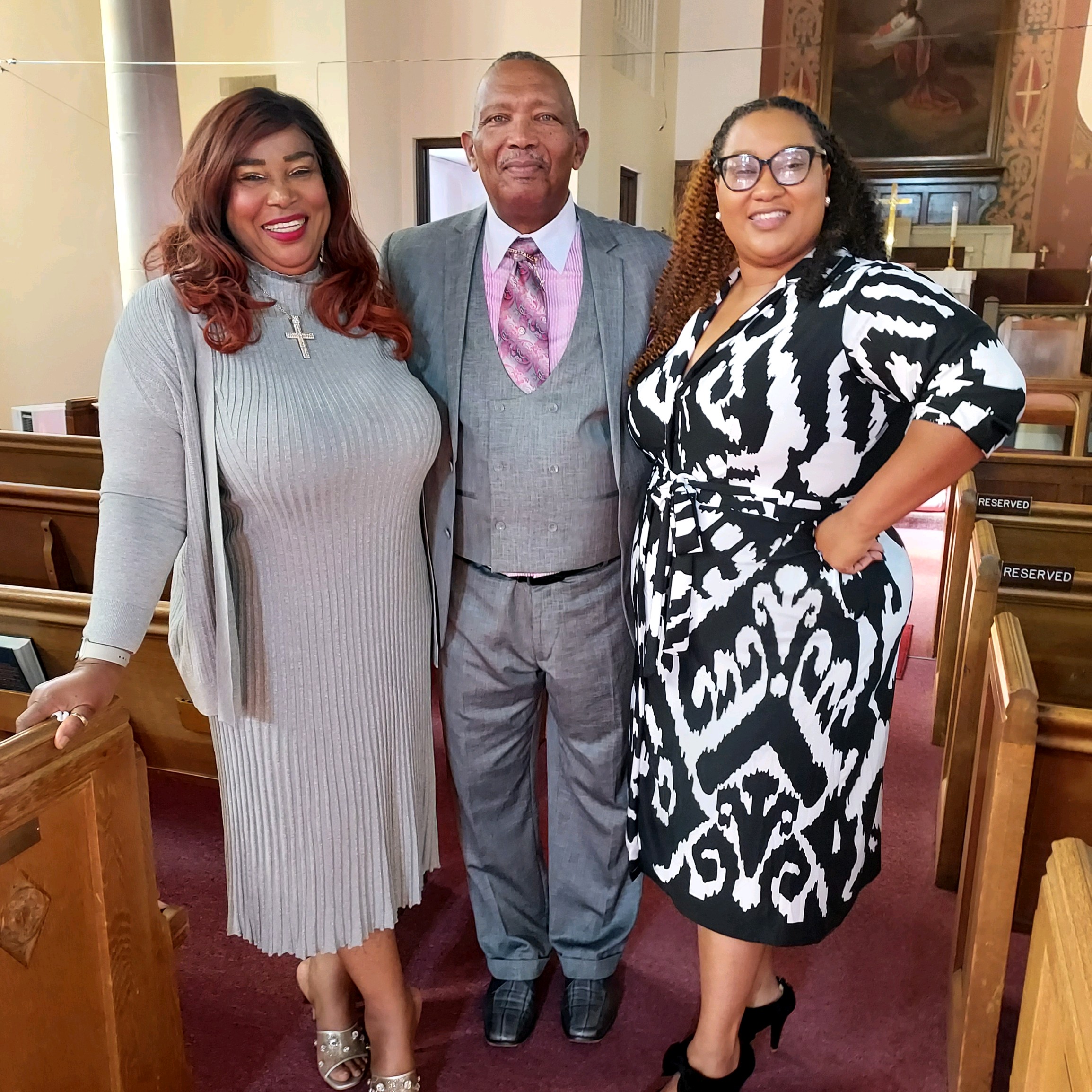 Three people smiling together inside Wayman’s sanctuary